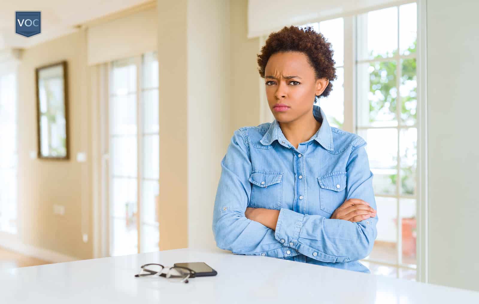 woman-crossing-her-arms-overlooking-keys-on-counter-because-she-cant-go-anywhere-to-do-harrassment-by-timeshare-services