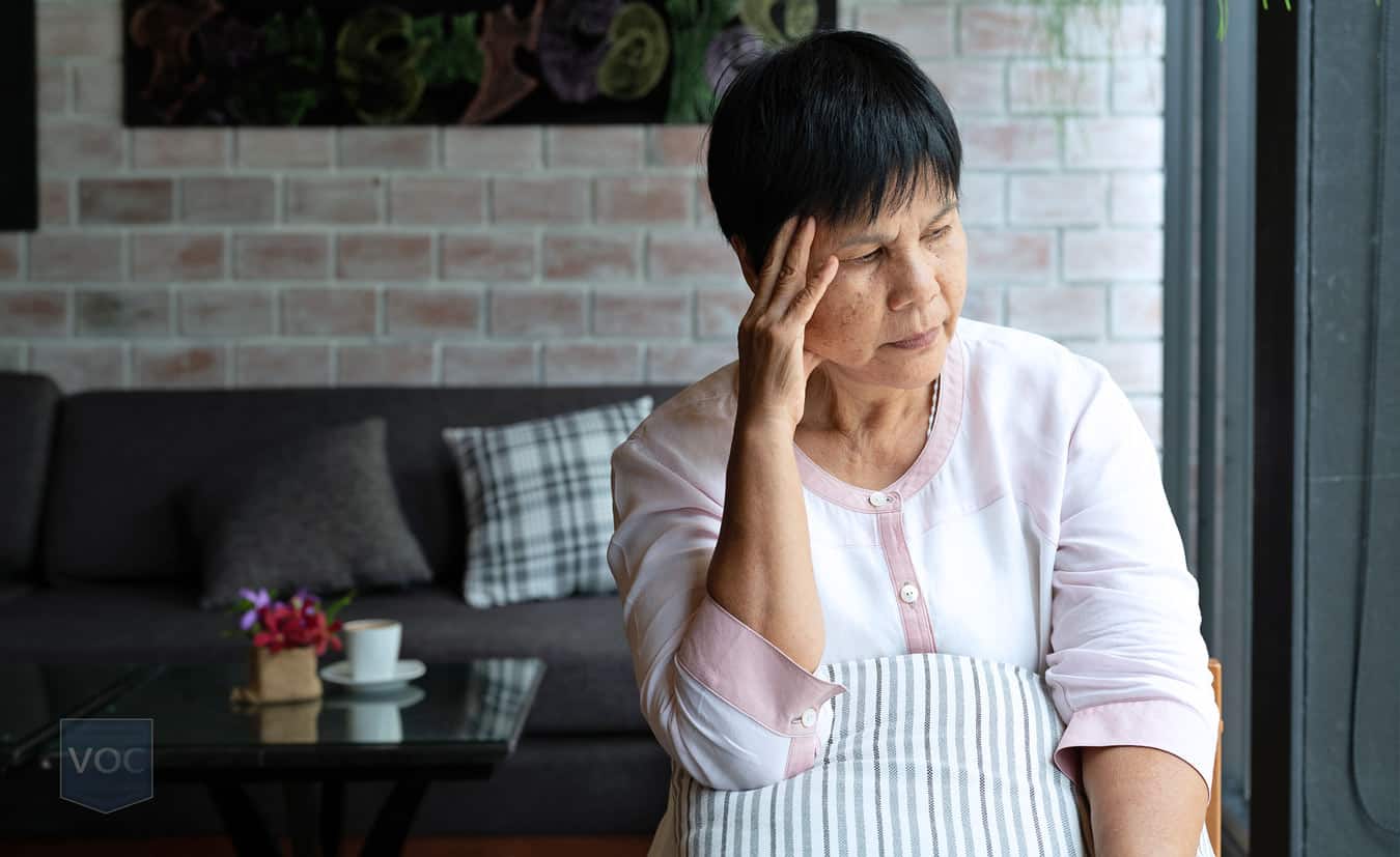 asian-woman-with-hand-on-head-on-couch-contemplating-what-to-do-with-her-timeshare-travel-package-that-isn't-working-out