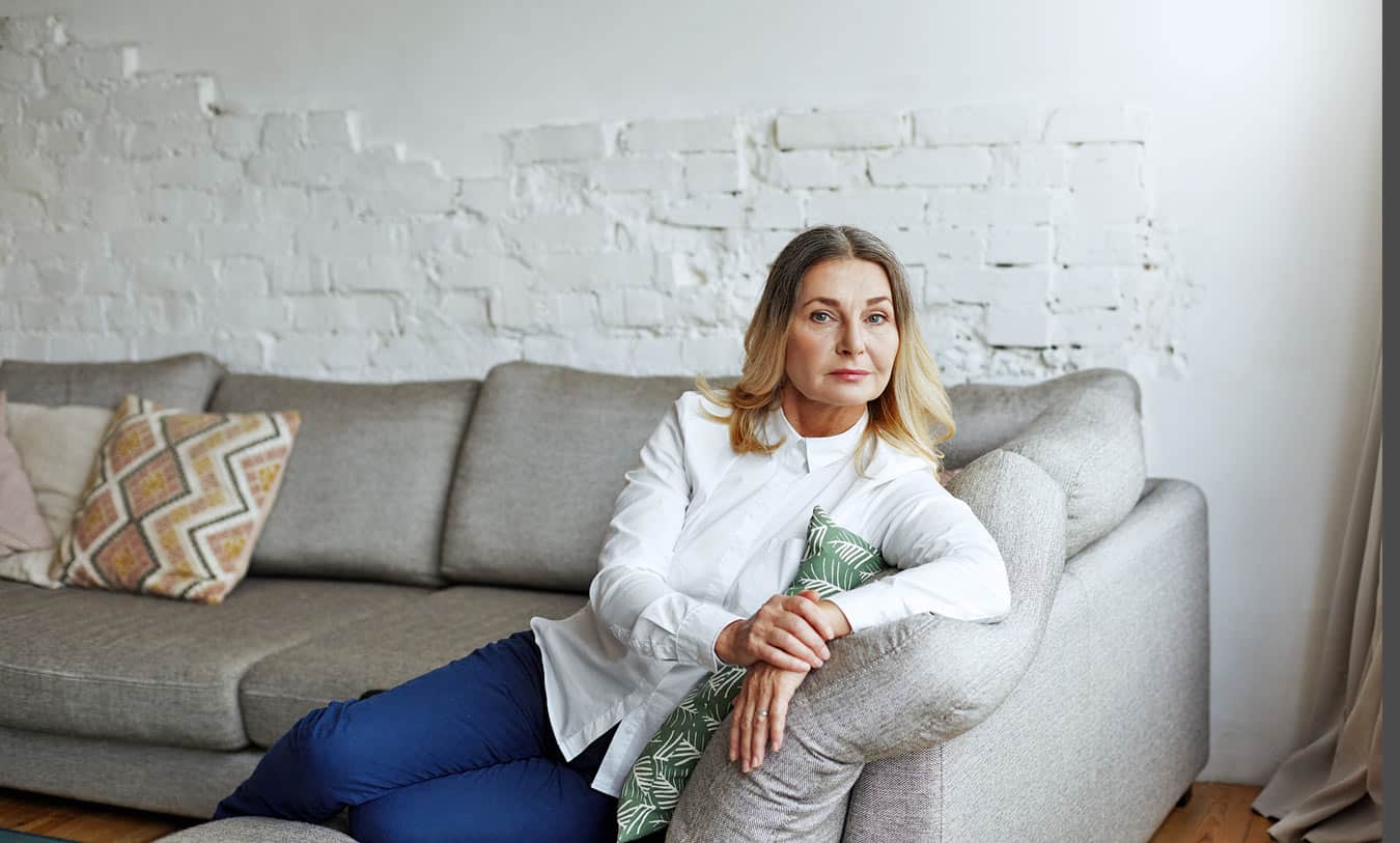 hugging-pillow-white-woman-looking-towards-window-day-dreaming-about-settling-with-the-timeshare-instead-of-taking-legal-action