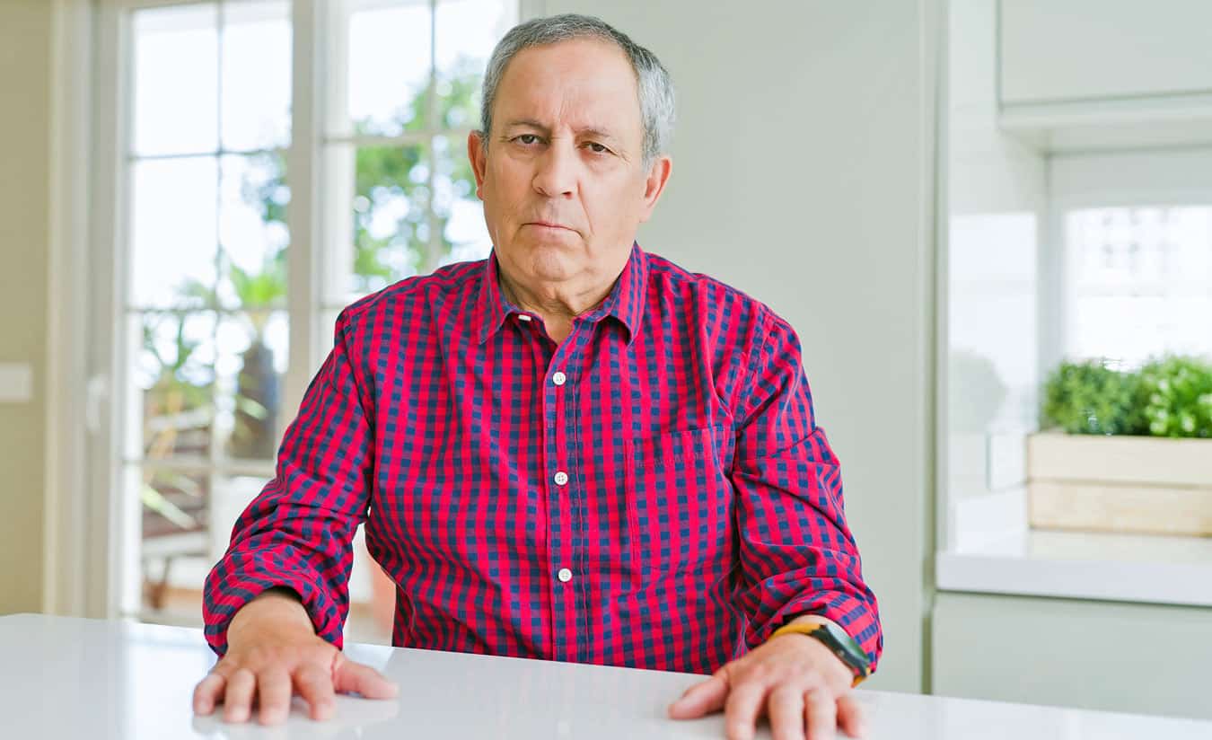 older-man-at-kitchen-counter-looking-displeased-because-he-cant-give-away-timeshare-weekly-interval-as-easy-as-thought