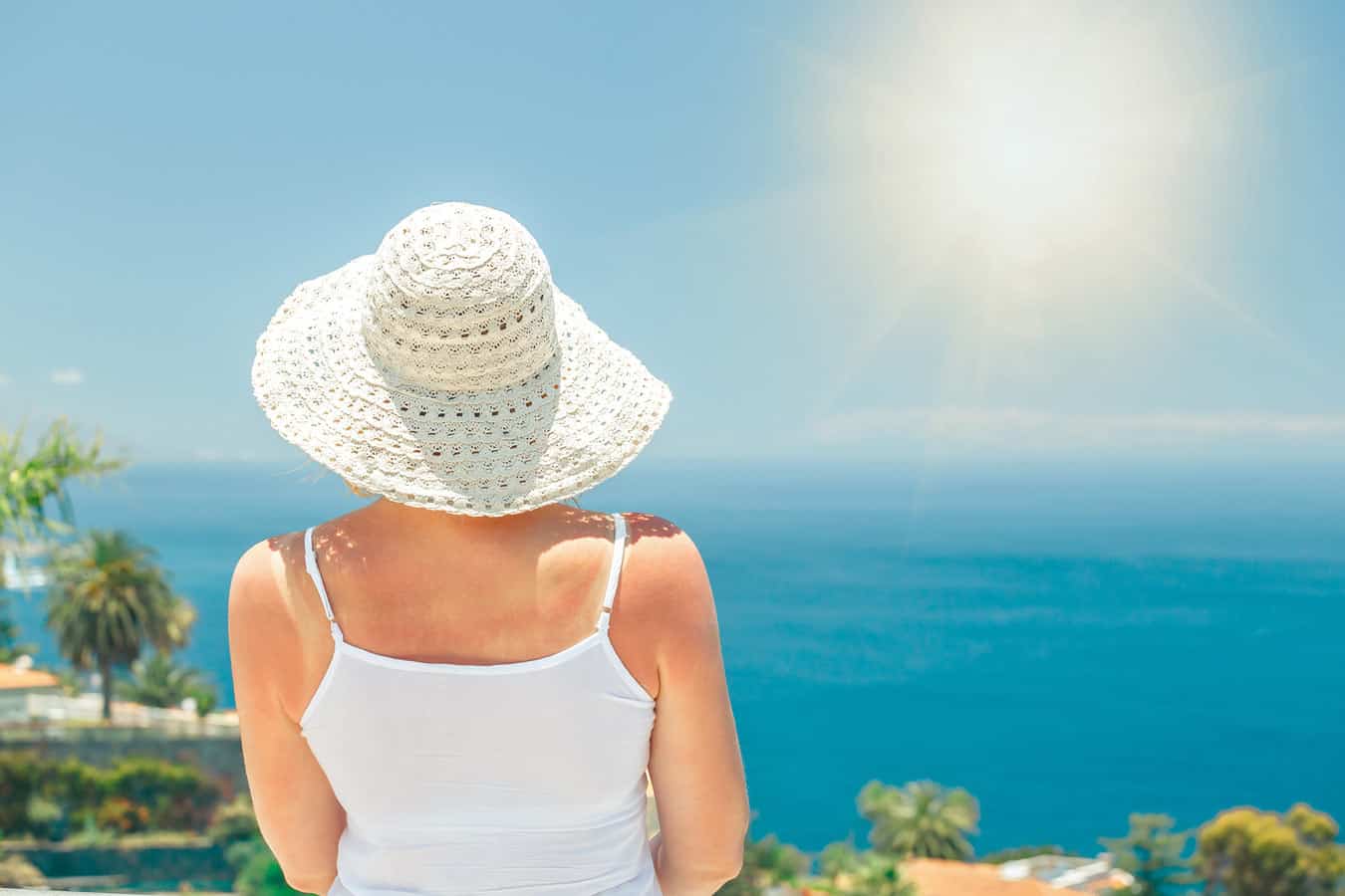 older-woman-staring-at-ocean-while-on-vacation-at-condo-thinking-about-giving-away-timeshare-interval