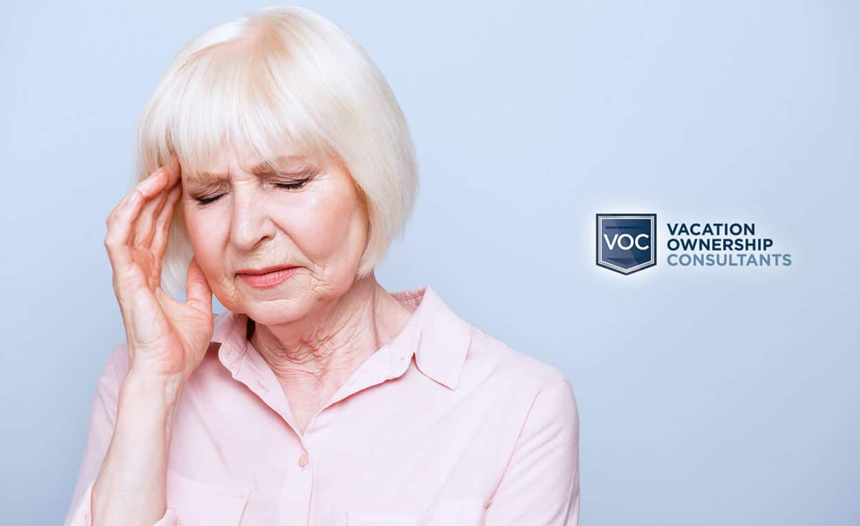 pink-shirted-older-woman-pressing-on-head-distraught-over-bad-purchase