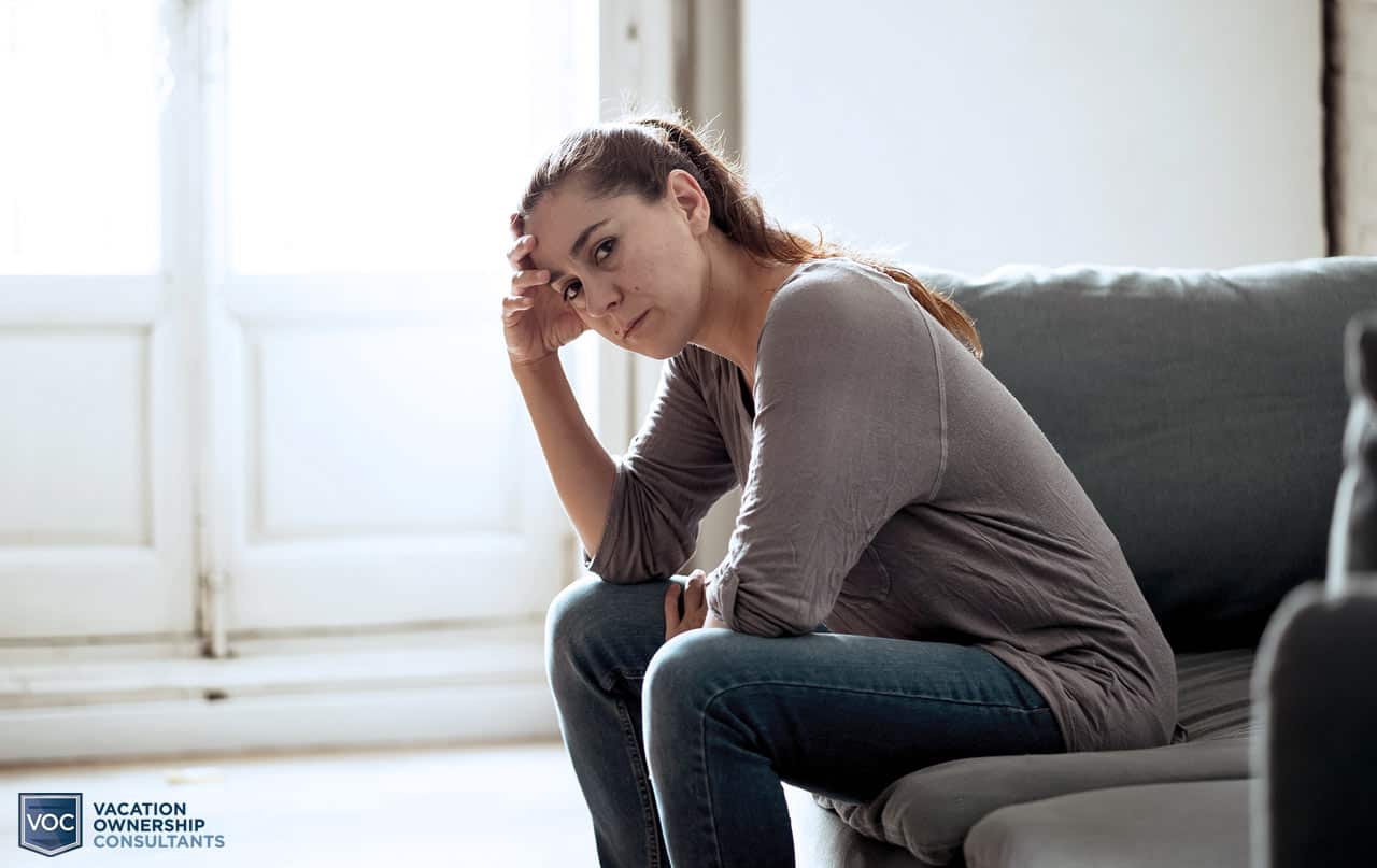 depressed-middle-aged-woman-sitting-on-couch-alone-in-dark-space-wondering-if-shell-ever-be-able-to-sell-her-timeshare