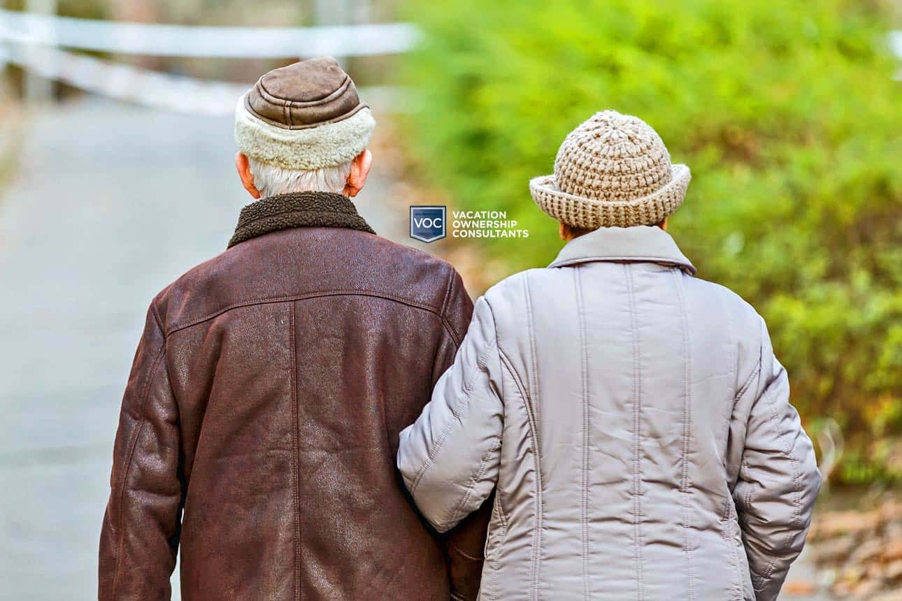 elderly-couple-in-80s-escape-for-walk-down-street-with-jackets-on-after-rainfall