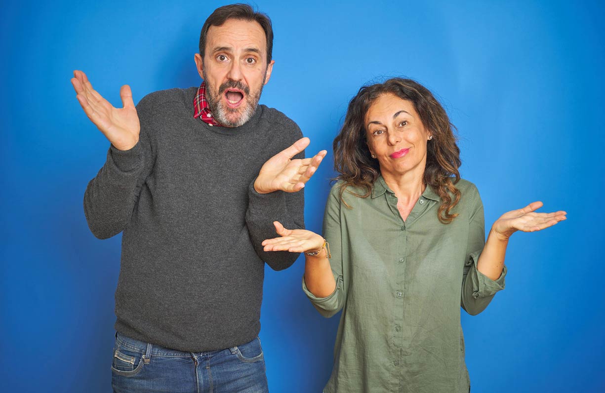 blue-backdrop-shoulder-shrugging-husband-and-wife-wondering-about-timeshare