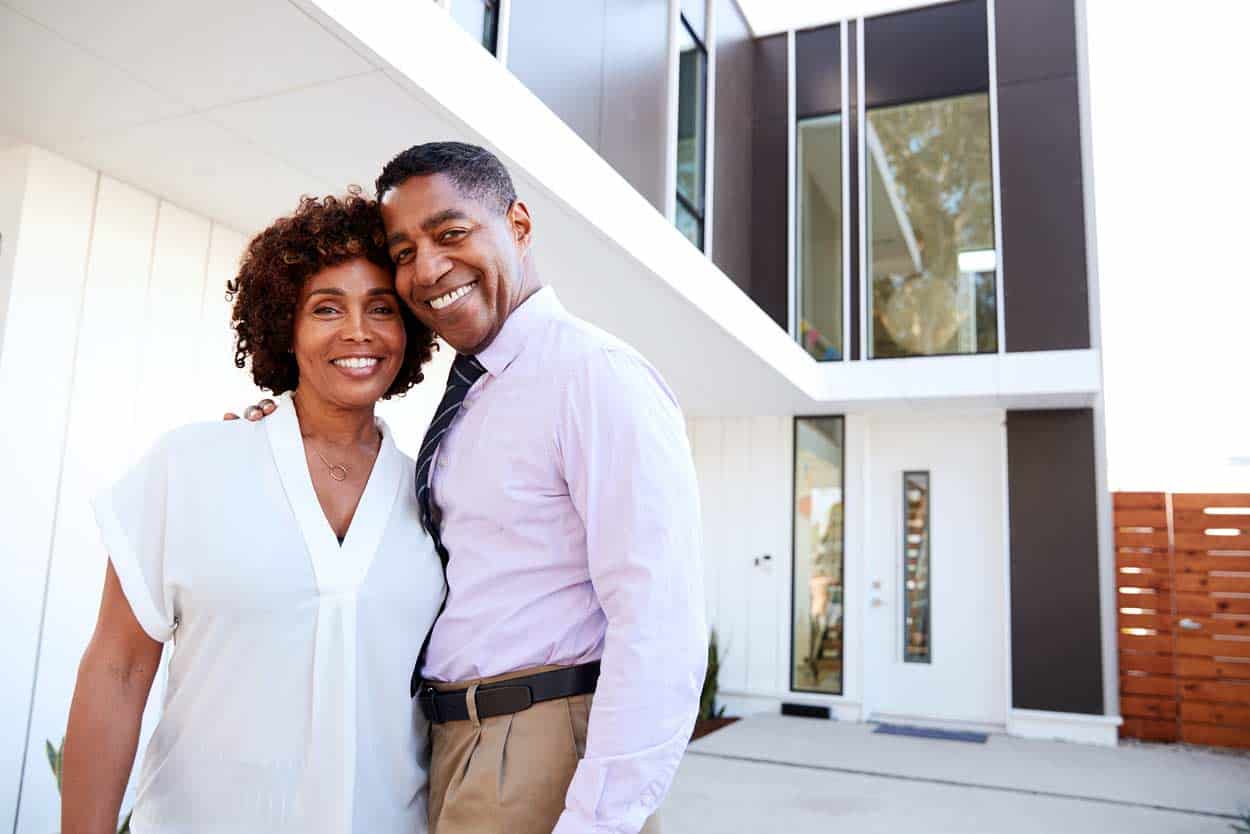 couple-posing-in-front-of-timeshare-after-inheriting-property-as-heir-to-parent