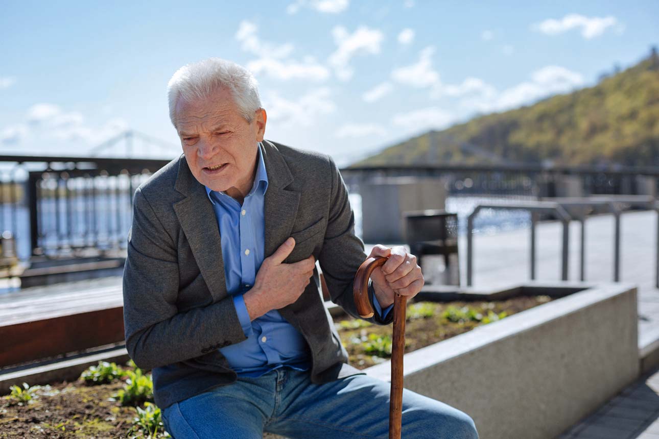 older-man-sitting-on-boardwalk-holding-chest-pain-with-cane-no-one-around-to-help-during-covid-19-pandemic-timeshare-ownership-worse