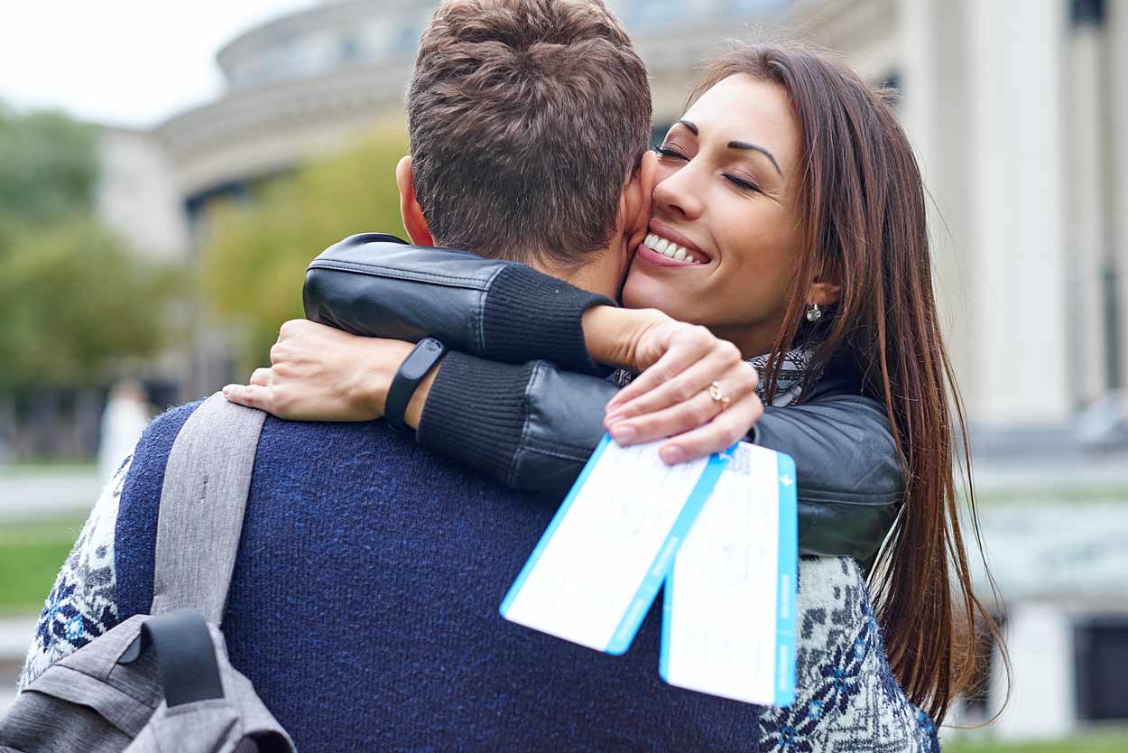 wife-hugging-husband-after-receiving-tickets-of-some-sort-attraction-appreciation-during-vacation