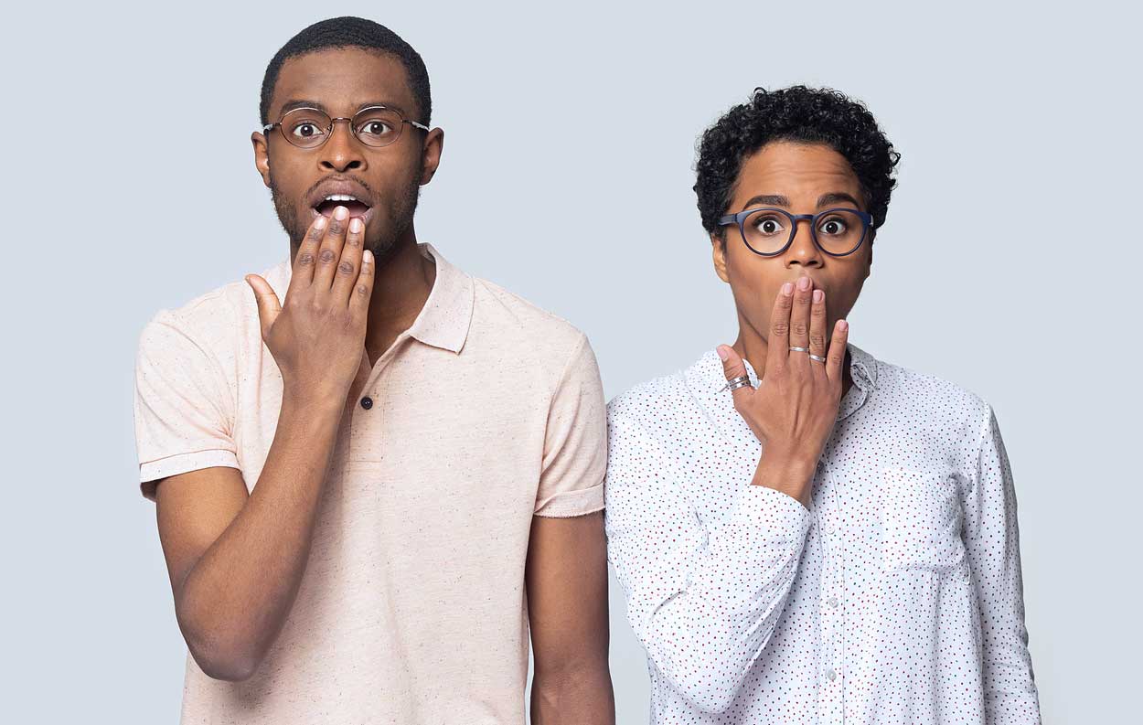 hand-on-mouth-african-american-man-and-woman-in-awe-of-some-sort-of-presentation-shocked-white-background