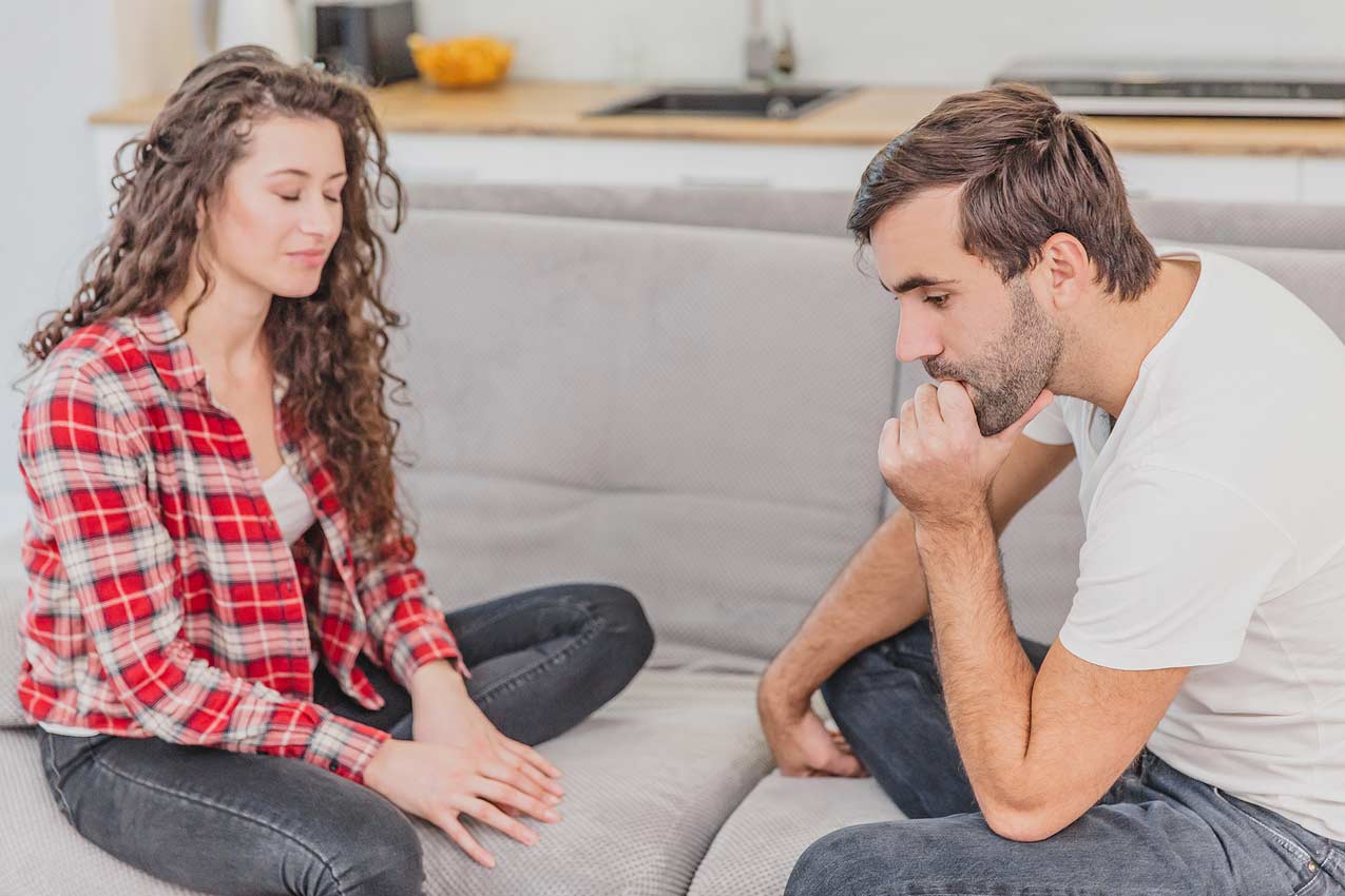 husband-and-wife-coming-to-conclusion-they-both-made-terrible-timeshare-mortgage-decision-and-looking-for-a-way-to-get-out-while-on-the-couch-at-home