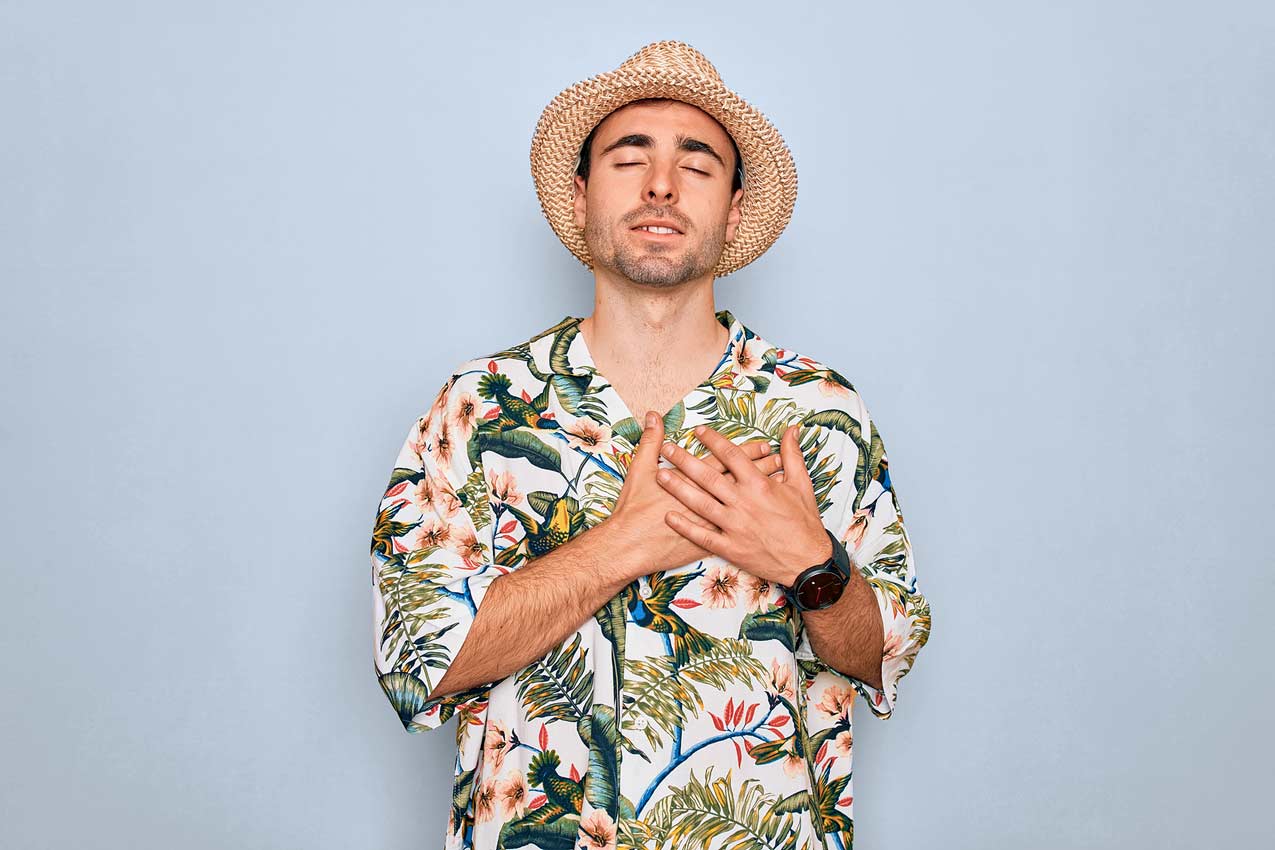 young-man-fidora-beach-attire-holding-heart-as-if-some-trip-advisor-read-his-mind-and-treated-him-fairly-for-vacation