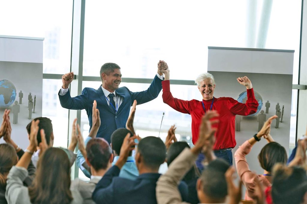 celebratory-timeshare-sales-reps-after-big-deal-closes-with-employee-on-stage-receiving-honor-and-praise-to-feel-apart-of-team-environment