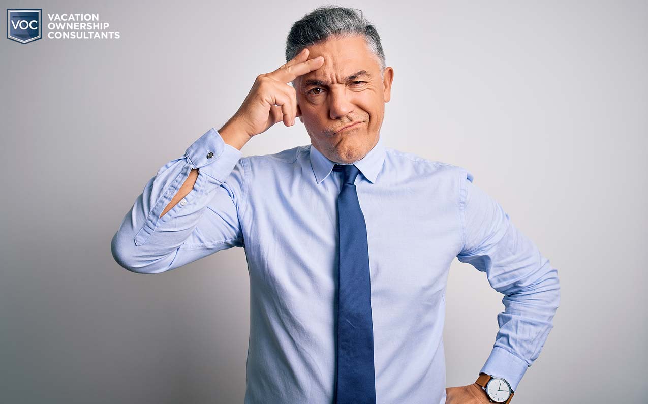 yes-man-in-tie-slick-hair-aging-with-gray-background-following-confusing-orders-to-make-money-at-any-cost-timeshares